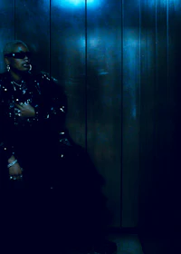 a person in a black jacket sitting in an elevator