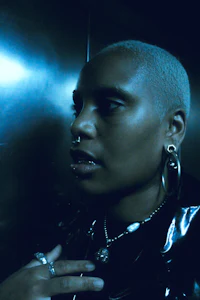 a woman in a black jacket standing in an elevator